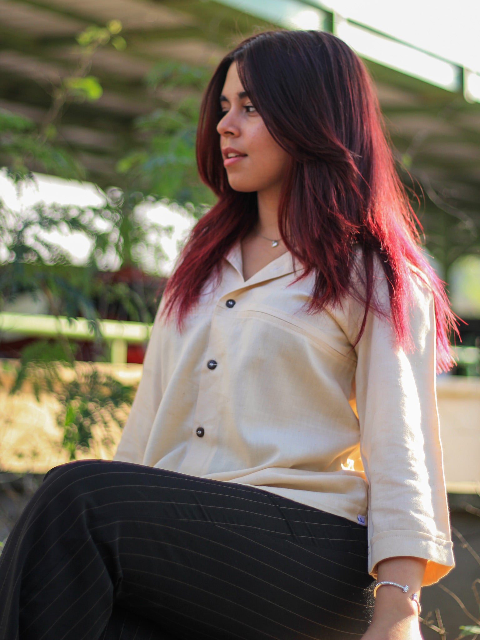 Model wearing Evara’s Buttercream Bliss Button-Down Shirt, crafted from a premium blend of banana fiber and cotton. This elegant three-quarter sleeve shirt in a golden hue features a mandarin collar, a structured yet relaxed fit, and a stylish button-down front. Designed for effortless versatility, it pairs perfectly with both formal and casual looks. Designed for consumers who appreciate natural fabrics and timeless fashion. Shop clothing at Evara.