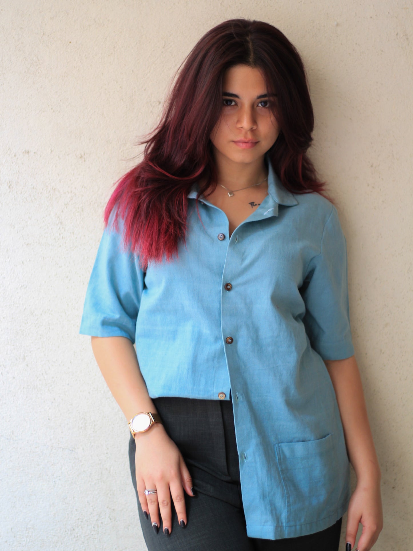 Model wearing Evara’s Aqua Petal Half-Sleeve Button-Down Shirt, made from a sustainable blend of banana fiber and cotton. This lightweight, breathable shirt features a structured silhouette, soft texture, and natural sheen, offering all-day comfort with moisture-wicking properties. A versatile wardrobe staple, ideal for casual and smart-casual looks. Shop eco-friendly fashion at Evara.
