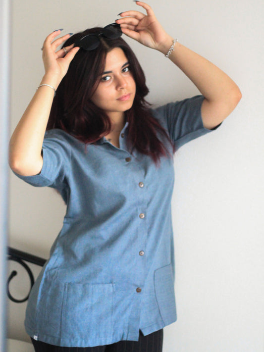 Model wearing Evara’s Moonlit Bay Half-Sleeve Button-Down Shirt, made from a sustainable blend of banana fiber and cotton. This lightweight, breathable shirt features a structured silhouette, soft texture, and natural sheen, offering all-day comfort with moisture-wicking properties. A versatile wardrobe staple, ideal for casual and smart-casual looks. Shop eco-friendly fashion at Evara.