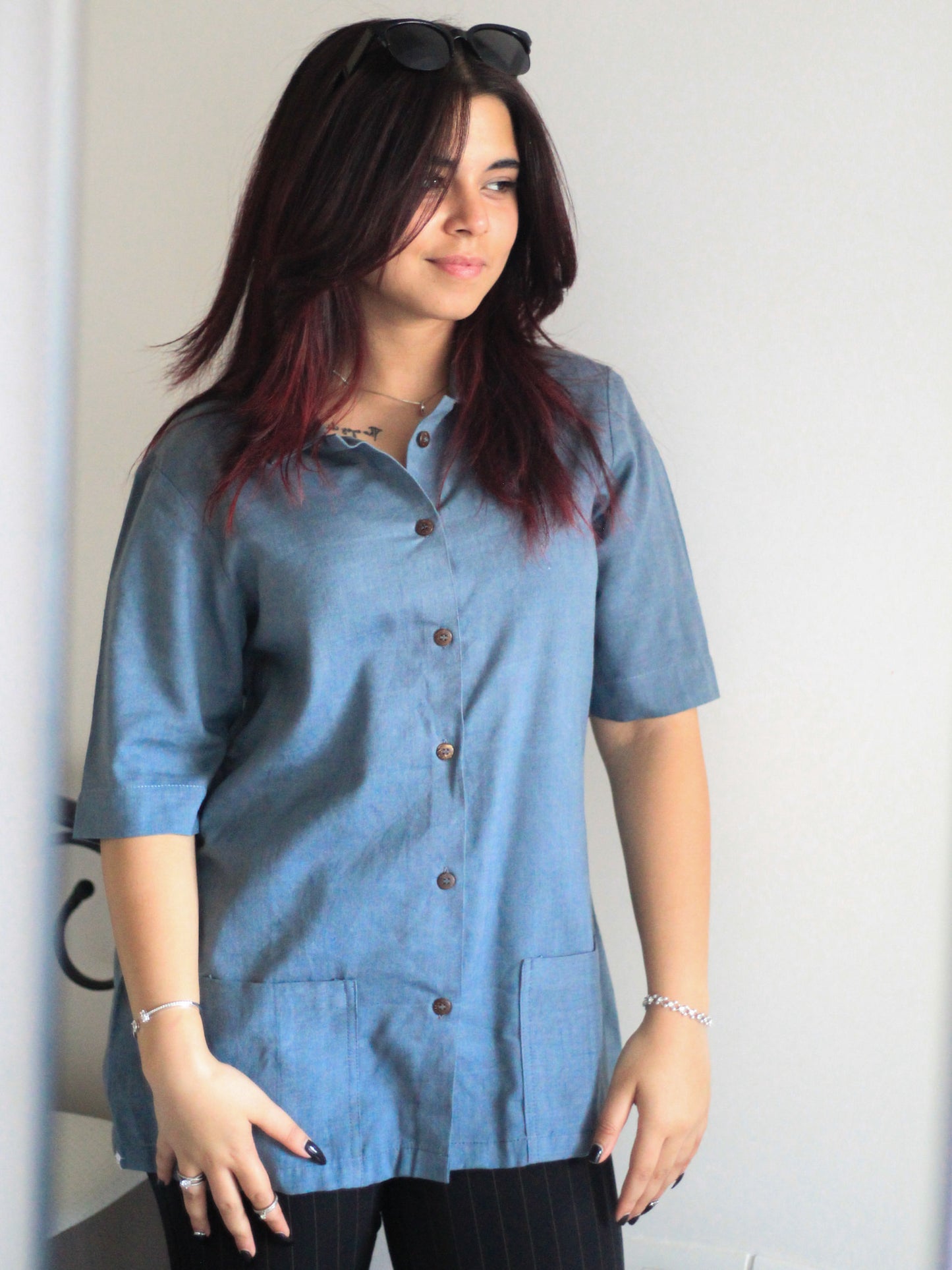 Model wearing Evara’s Moonlit Bay Half-Sleeve Button-Down Shirt, made from a sustainable blend of banana fiber and cotton. This lightweight, breathable shirt features a structured silhouette, soft texture, and natural sheen, offering all-day comfort with moisture-wicking properties. A versatile wardrobe staple, ideal for casual and smart-casual looks. Shop eco-friendly fashion at Evara.