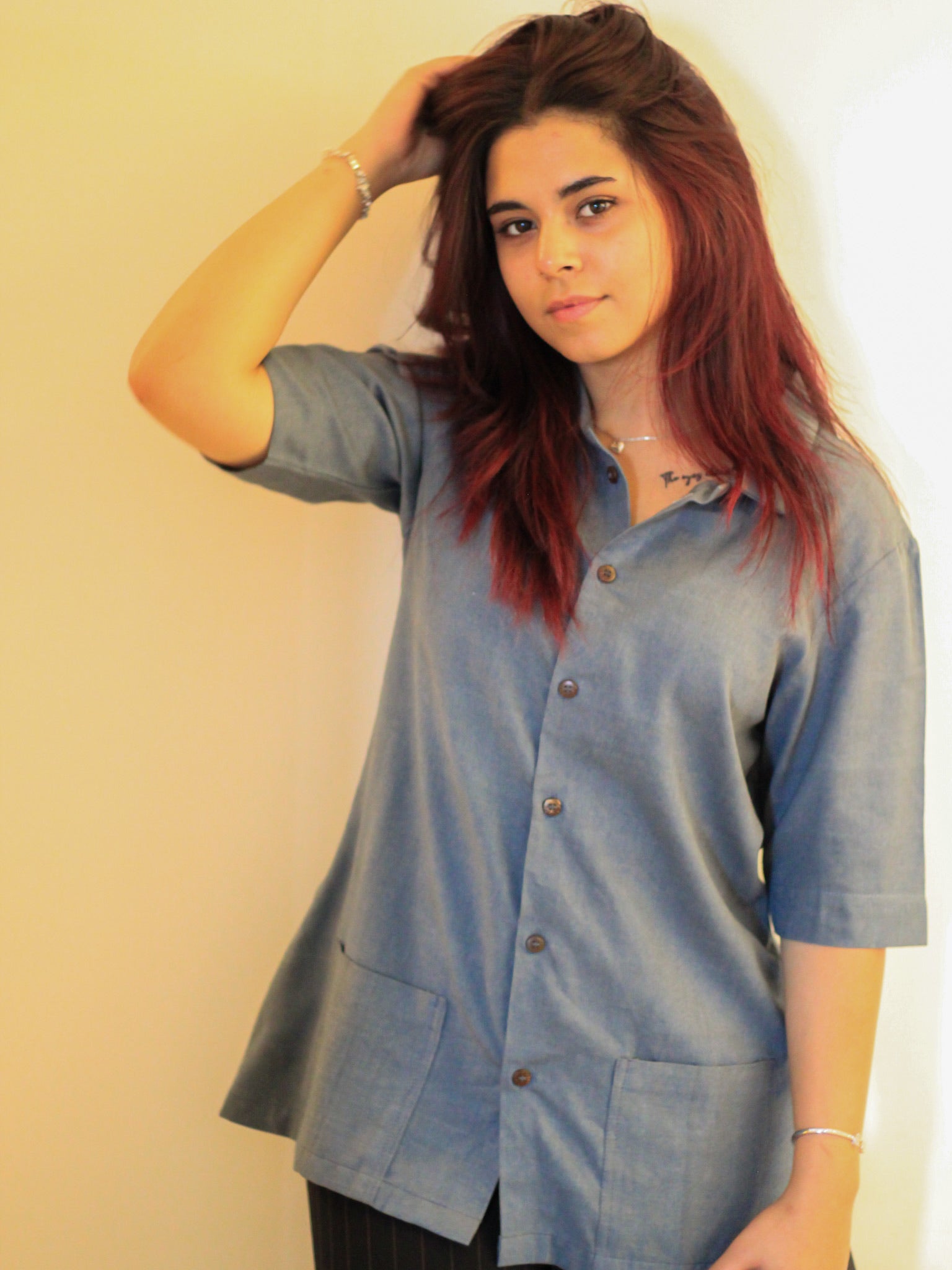 Model wearing Evara’s Moonlit Bay Half-Sleeve Button-Down Shirt, made from a sustainable blend of banana fiber and cotton. This lightweight, breathable shirt features a structured silhouette, soft texture, and natural sheen, offering all-day comfort with moisture-wicking properties. A versatile wardrobe staple, ideal for casual and smart-casual looks. Shop eco-friendly fashion at Evara.